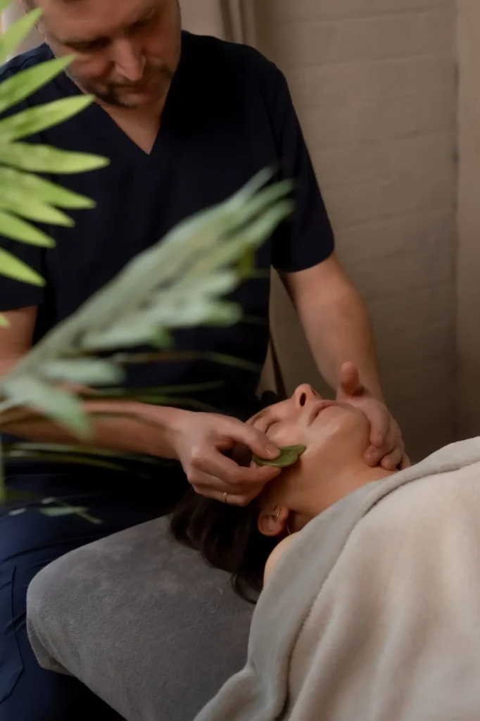 gua sha facial massage treatment in beauty salon